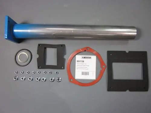 Remeha-Komponenten für ein Rücklaufwasserrohr, darunter eine Metallröhre, Dichtungen, ein Lager sowie Schrauben und Unterlegscheiben auf grauem Hintergrund.